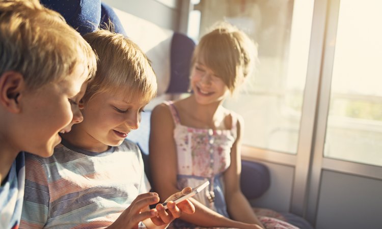 Children seated together on a train. 